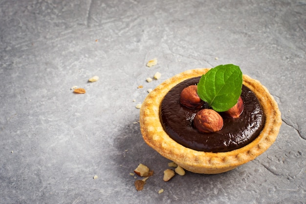 Petite tarte au chocolat aux amandes sur fond de pierre grise, espace pour le texte