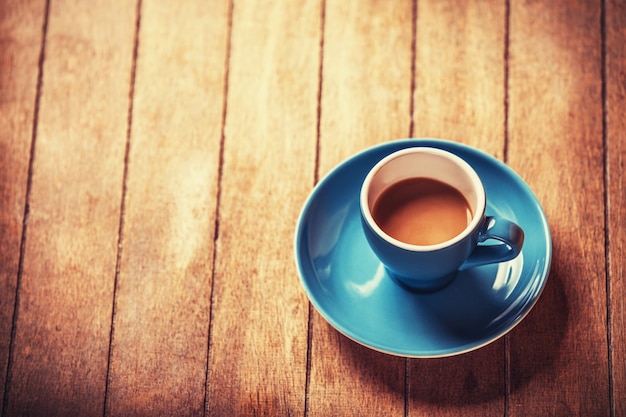 Petite tasse bleue du café sur une table en bois