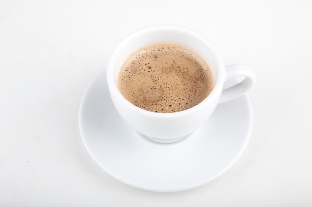 petite tasse de cacao sur fond blanc dans une tasse blanche