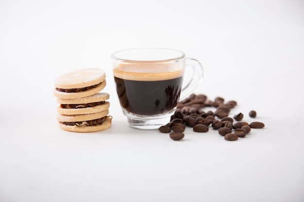 Petite tasse en verre de café expresso gourmet servant avec des biscuits alfajores