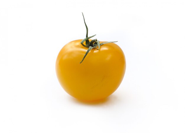 Petite tomate jaune isolée sur blanc