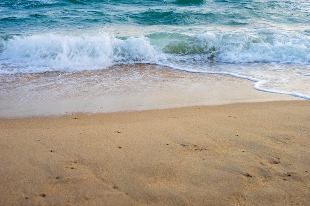 Petite vague se déplaçant sur le sable jaune sur la plage avec de l&#39;eau de mer claire.