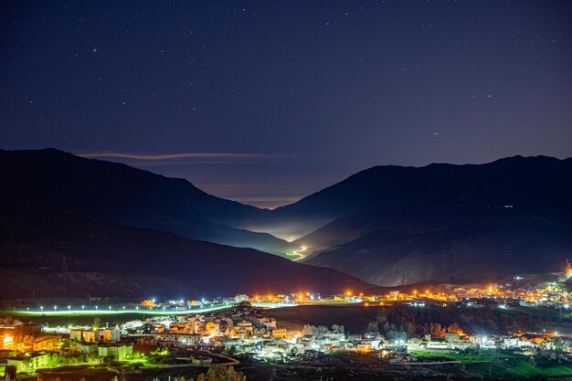 Photo une petite ville dans les montagnes la nuit avec quelques lumières allumées.