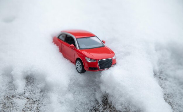 Petite voiture de jouet rouge sur la neige en hiver