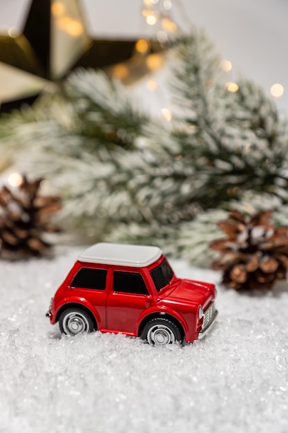 Petite voiture rouge miniature avec des épinettes vacances d'hiver arrière-plan concept de Noël livraison de vacances décorations de Noël et lumières bokeh