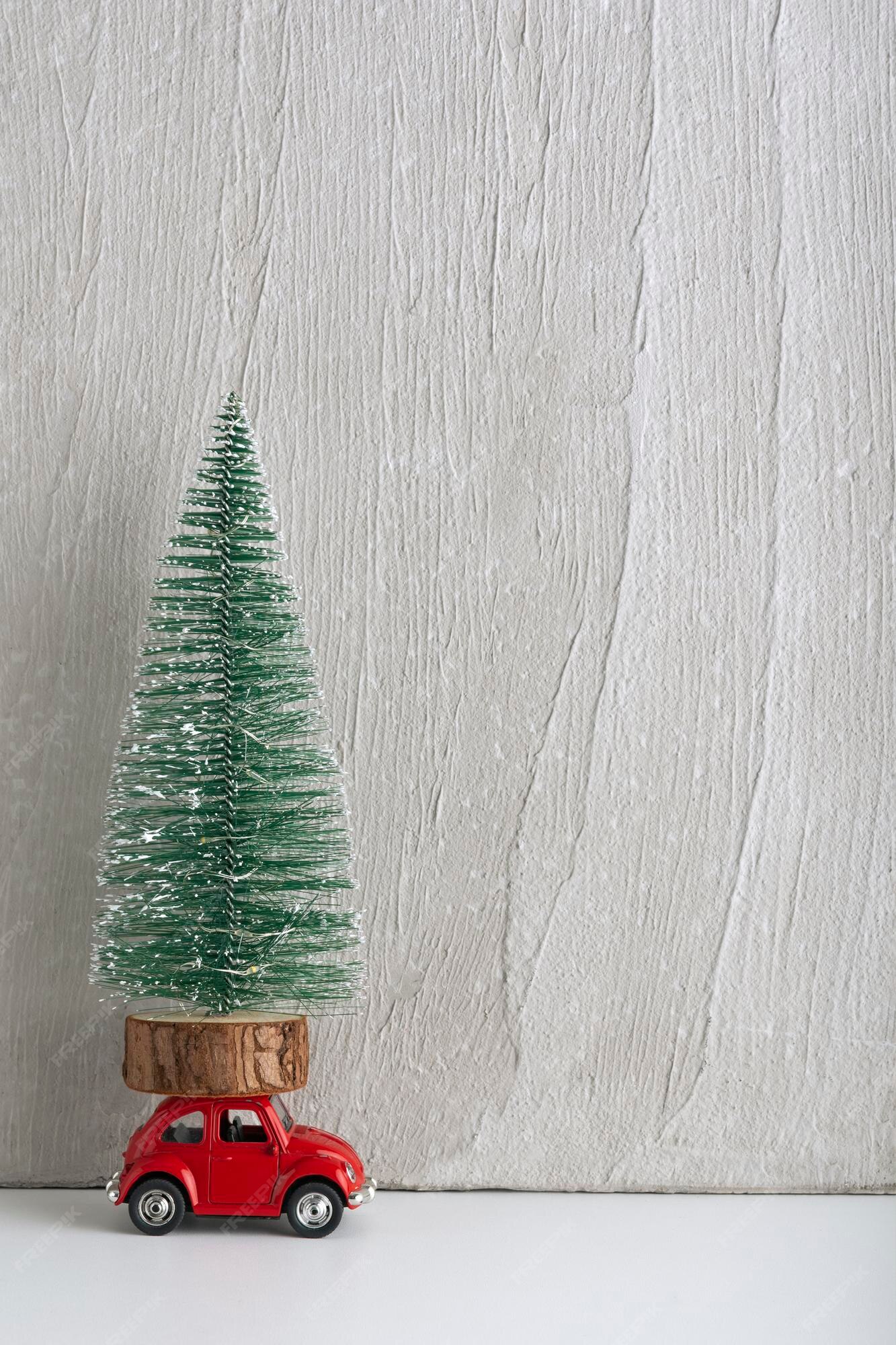 Petite voiture avec sapin de Noël sur le toit Voiture en cadeau sous le