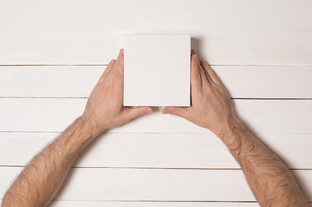 Petites boîtes en carton blanc dans les mains des hommes.