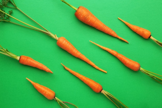 Petites carottes sur fond vert Photo à couche plate Vue supérieure