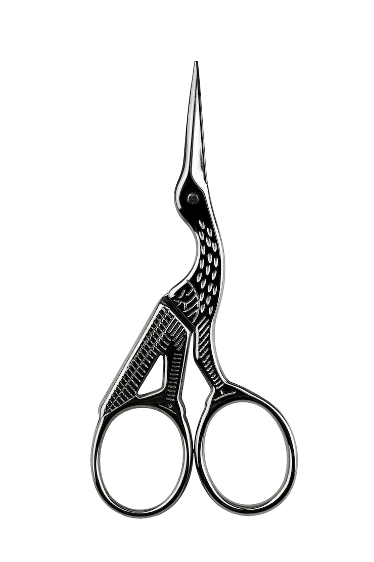 Photo petites ciseaux à ongles métalliques en forme de cigogne isolées sur un fond blanc