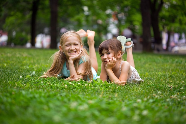 Petites copines de filles souriantes sur la pelouse