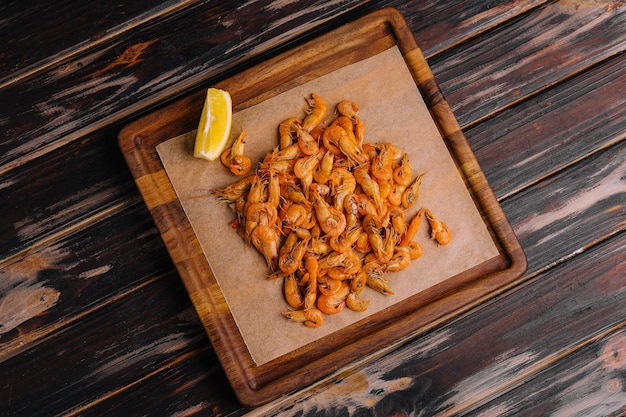 Petites crevettes cuites sur plateau en bois