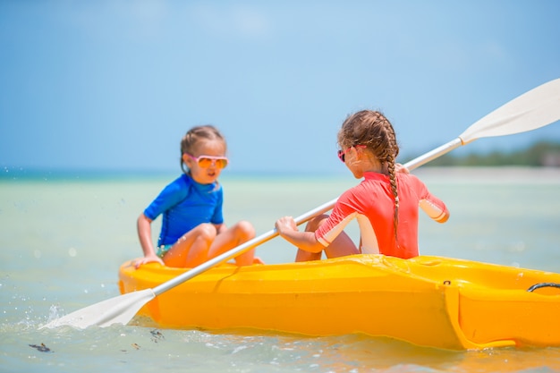 Petites filles adorables appréciant le kayak sur kayak jaune