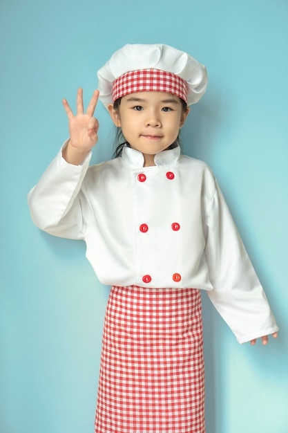 Petites filles asiatiques en uniforme de chef avec pose okie