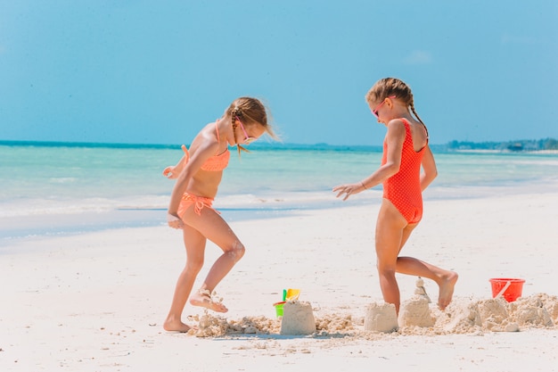 Petites filles heureuses s'amusant sur la plage