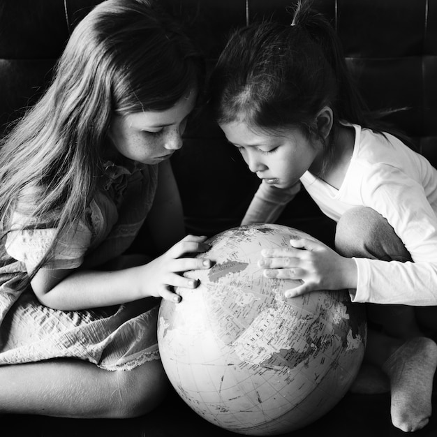 Petites filles jouant avec un globe