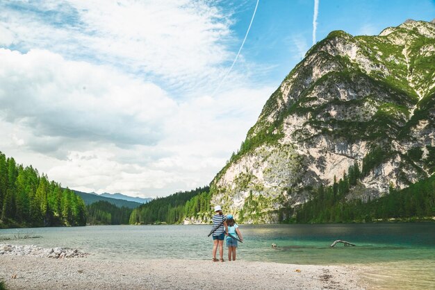 Petites filles marchant sur la plage du lac dans les montagnes