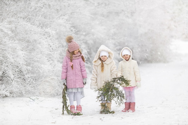 Petites filles mignonnes en hiver dans la neige avant la promenade du nouvel an