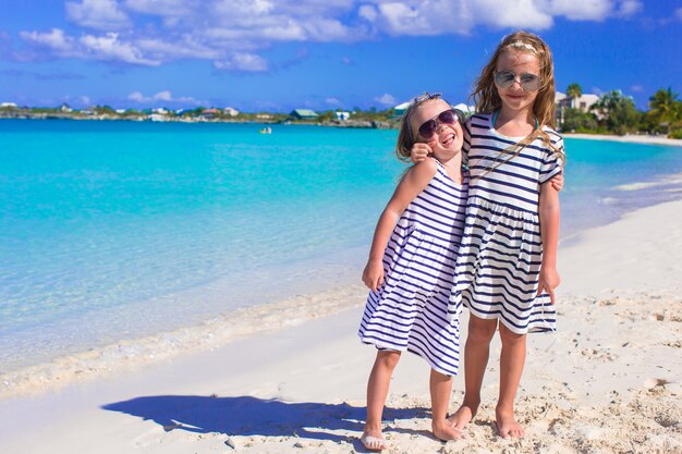 Petites filles s'amusant pendant des vacances à la plage tropicale