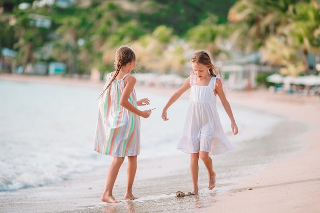 Petites filles s'amusant à profiter de vacances sur la plage tropicale