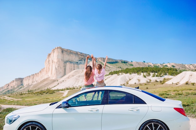 Les petites filles voyagent en voiture en vacances d'été dans les montagnes