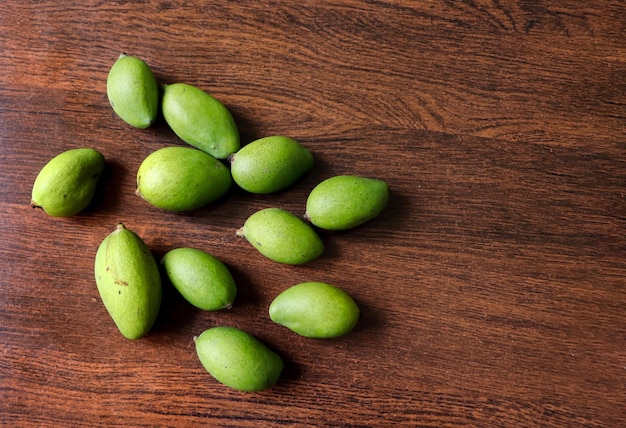 Petites mangues vertes sur une table en bois