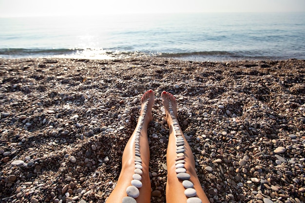 Petites pierres sur la jambe de la femme sur la plage