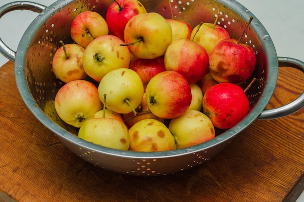 Petites pommes dans une colandre fraîches récoltées à l'automne