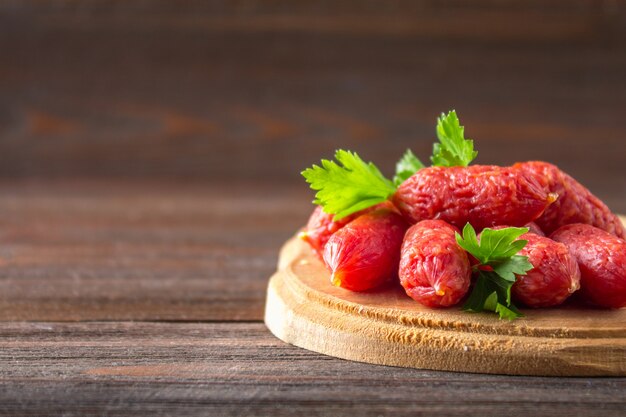 Petites saucisses fumées sur une table en bois