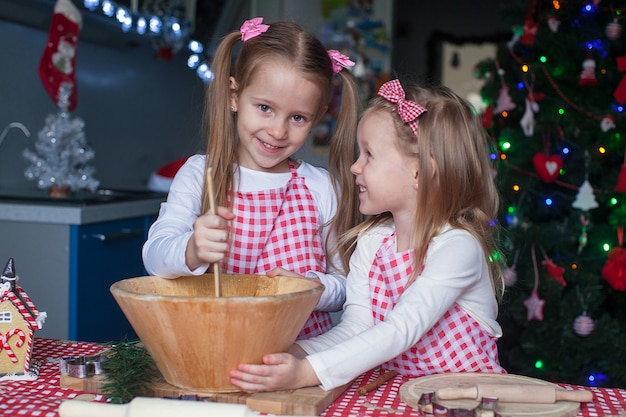 Petites sœurs mignonnes préparent des biscuits en pain d'épice pour Noël