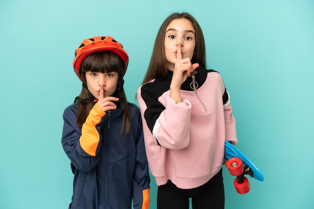 Petites soeurs pratiquant le cyclisme et patineur isolé montrant un signe de silence geste mettant le doigt dans la bouche