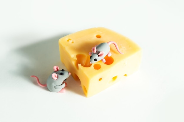 Petites souris en pâte à modeler et un morceau de fromage avec des trous