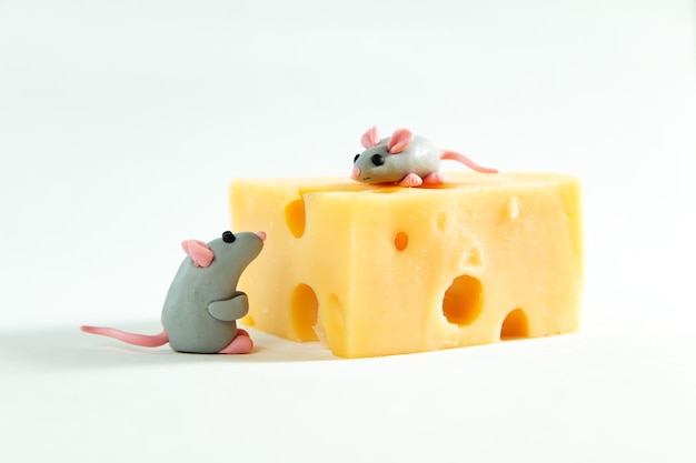 Petites souris en pâte à modeler et un morceau de fromage avec des trous