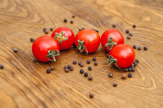 Petites tomates cerises rouges sur fond de planche de bois