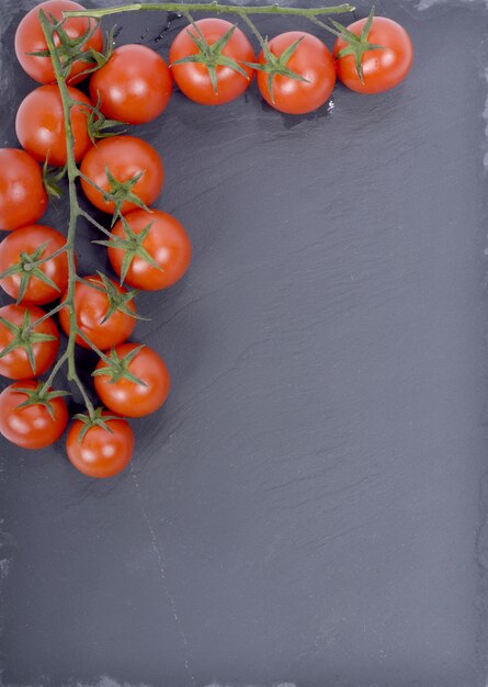 Petites tomates présentées sur une plaque en ardoise