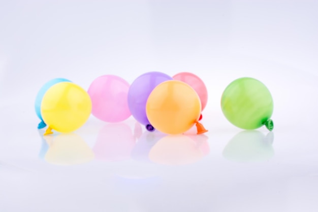 Petits ballons colorés sur fond blanc