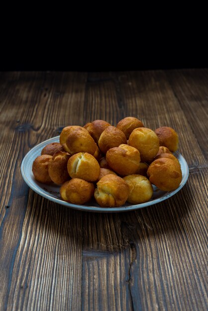 Petits beignets ronds sur table en bois