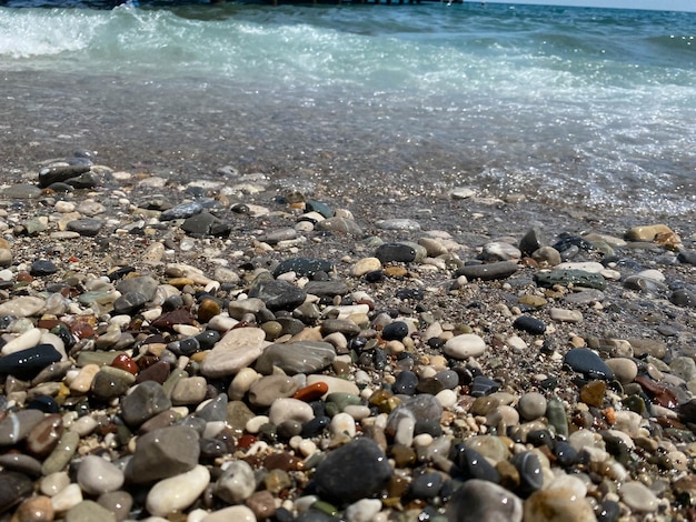 Petits cailloux éparpillés sur le sable de la plage gros planFaible profondeur de champMise au point sélective