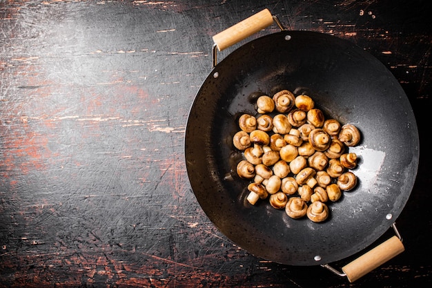 Petits champignons frits dans une poêle à frire