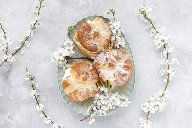 Petits choux avec de la crème fouettée et du sucre en poudre sur le dessus Pâte à choux dessert choux à la crème français