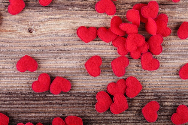 Petits coeurs en textile rouge sur fond en bois