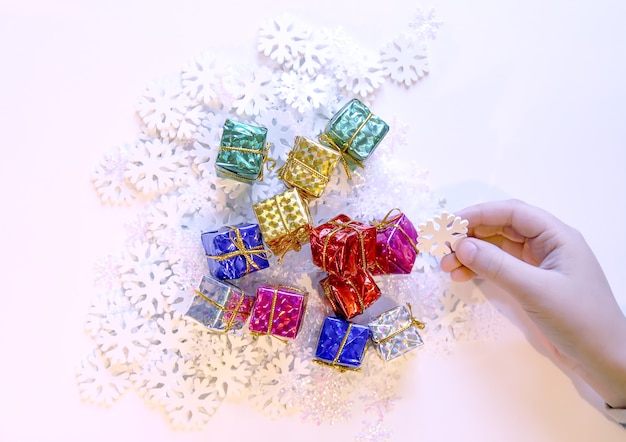 Petits coffrets cadeaux colorés dans les mains de l'enfant. Processus de décoration de Noël et du Nouvel An.