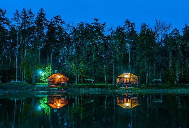 Petits cottages en bois en forêt la nuit