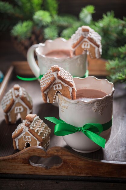 Petits cottages en pain d'épice avec chocolat chaud le soir d'hiver de Noël