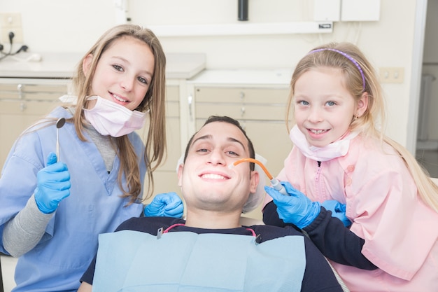 Petits dentistes examinant la bouche d&#39;un patient adulte