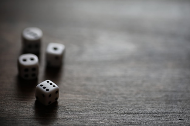 Petits dés blancs sur une table de texture en bois marron