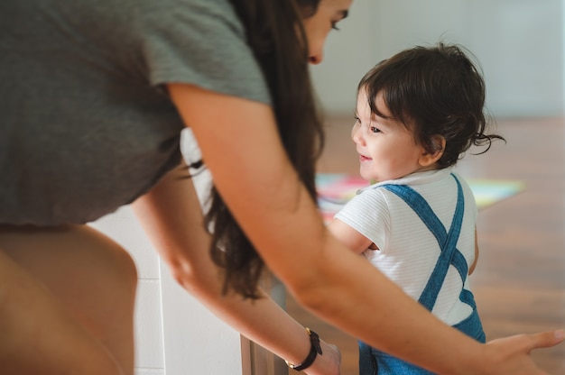 Photo les petits enfants en bas âge avec la première marche avec des escaliers à la maison, les petits bébés sont heureux de jouer et d'apprendre à ramper avec la famille, les bébés mignons s'amusant et s'occupant des enfants