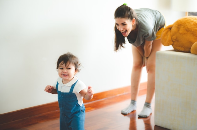 Les petits enfants en bas âge avec la première marche avec des escaliers à la maison, les petits bébés sont heureux de jouer et d'apprendre à ramper avec la famille, les bébés mignons s'amusant et s'occupant des enfants