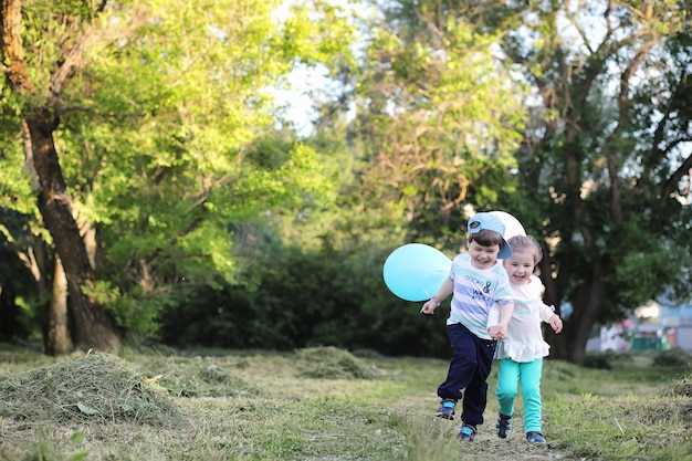 Les petits enfants marchent dans un parc avec des ballons