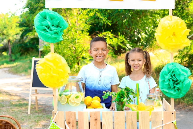 Petits enfants mignons au stand de limonade dans le parc