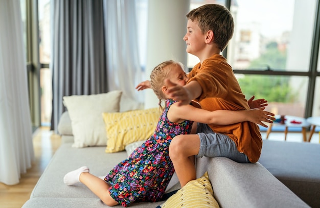 Les petits enfants mignons, les frères et sœurs s'embrassent et se font des câlins à la maison montrent de l'amour et des soins. Concept de soutien aux enfants de la famille